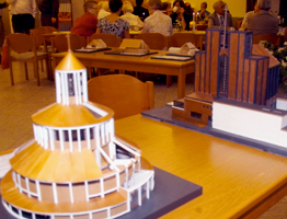 Vorne das Modell von Bartnings Rundkirche, im Hintergrund die Stahlkirche, hinten links kleinere Kirchen. KLICK öffnet Fenster über OBAK-Modellbau